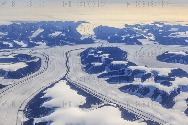 Aerial view of glaciers, glacier tongues and icy mountains on the coast, sunny, East Greenland,