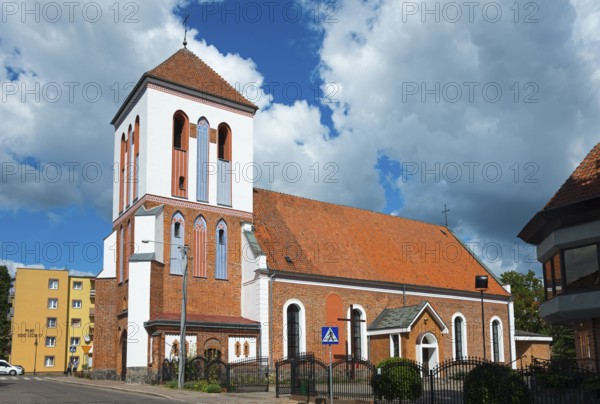 Historic church with brick tower in front of cloudy sky in city neighbourhood, Dominikuskirche,