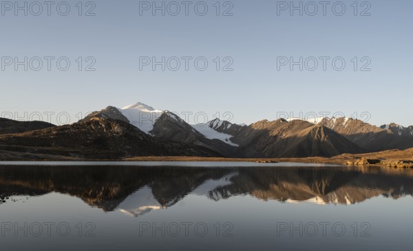 Glaciated mountain peaks reflected in a mountain lake at sunset, Arabel Lake at Arabel Pass, Issyk