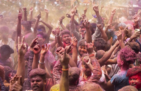 Revellers dancing in the beat of music as they celebrate Holi on a street, the Hindu spring