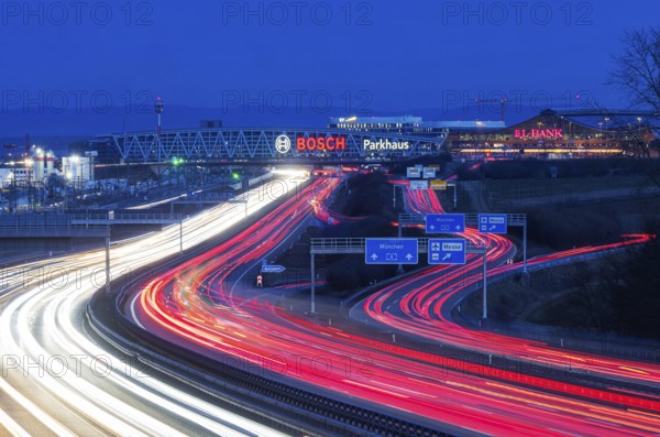 A8 motorway at Stuttgart Airport in the evening. Heavy traffic, lanes of light. Modern architecture