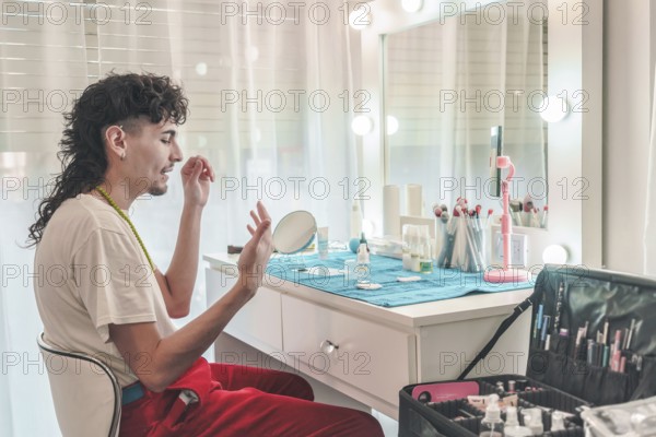Young male makeup artist applying foundation in front of a mirror at a professional beauty salon,