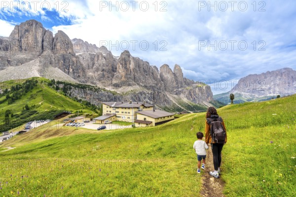 Tourists enjoying a summer hike through the stunning dolomites near gardena pass, italy, surrounded