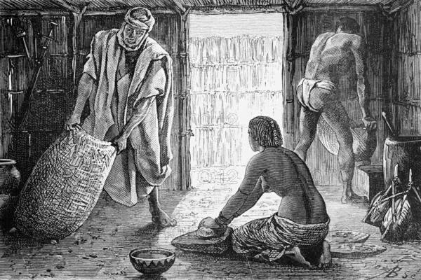 Interior of a hut in the Sahara oasis of Bardaï or Bardai, woman kneeling on the ground and