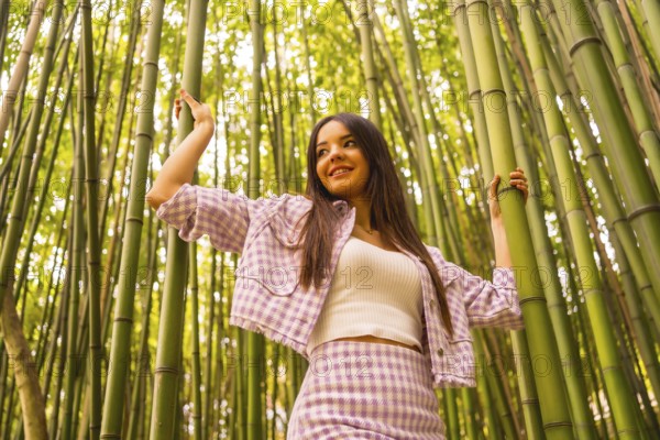 Young caucasian girl with a pink skirt in a bamboo forest. Enjoying summer holidays in a tropical