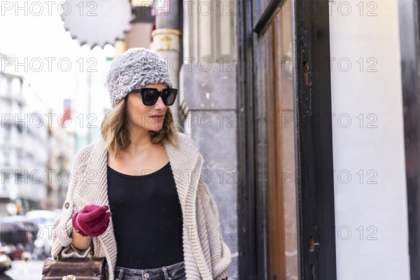 Lifestyle, young Caucasian blonde girl enjoying and smiling in the city in winter. Strolling with