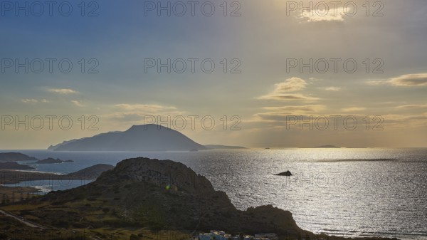 Glittering sea in front of islands in the evening light with dawning sky, Arkasa, west coast,