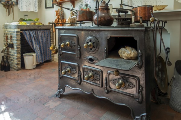 Antique cast-iron stove in kitchen inside 18th century clergy house Schriek at recreated village in