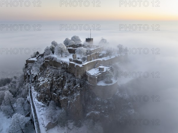 Aerial view of the Hegau volcano Hohentwiel with Germany's largest fortress ruins on a cold, foggy