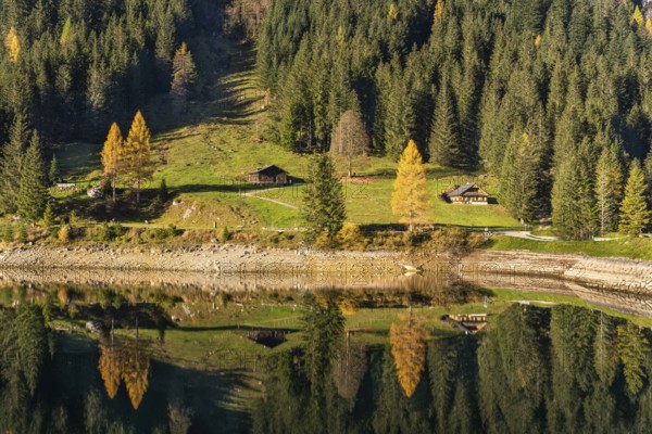 The Vordere Gosausee and the hiking trail around the lake in autumn. Two typical houses. Yellow