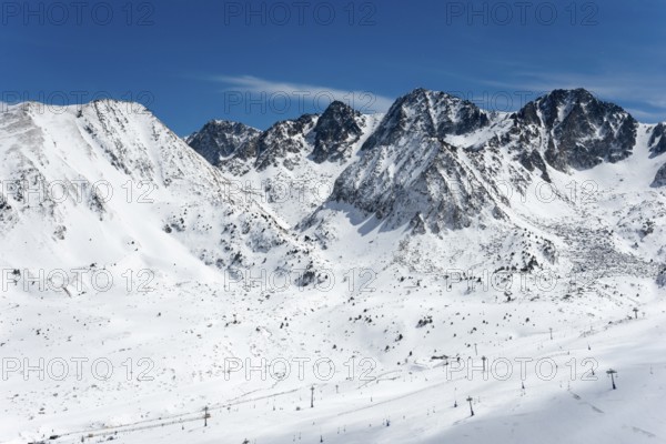 Schneebedeckte Berggipfel unter klarem Himmel in den winterlichen Bergen von Andorra, Skigebiet,