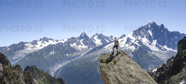 Mountaineer standing on a rock, mountain landscape with mountain peak Aiguille Verte, Mont Blanc