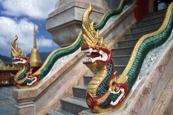 Dragon on staircase of tower with top of Chedi highest building in temple complex buddhist
