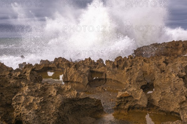 The rocks are scattered throughout the area, with some of them being large and jagged. The water