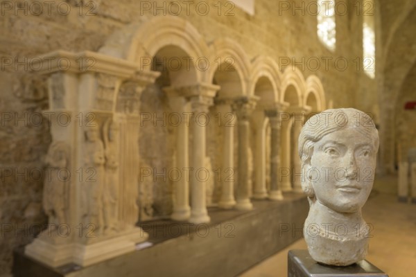 Stone female head in the museum at Gellone Abbey, also Saint-Guilhem-le-Désert Monastery,
