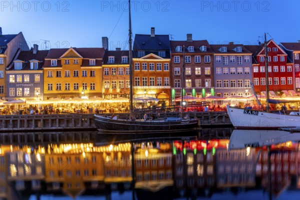 Colourful houses, restaurants and historic ships on the Nyhavn canal and harbour at dusk,
