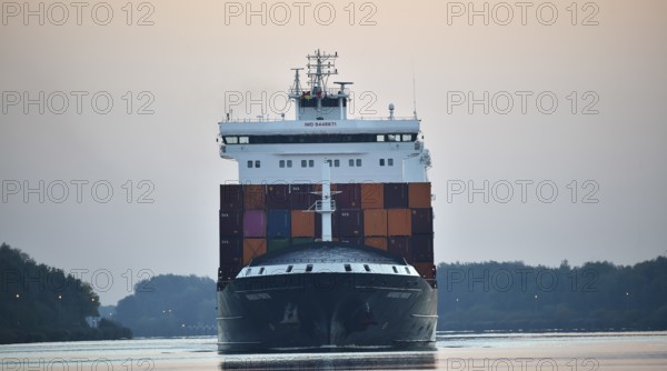 Container ship Nordic Porto sailing at sunrise in the Kiel Canal, Kiel Canal, Schleswig-Holstein,