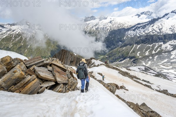 Mountaineer on a rocky ridge with snow, descent from the summit of Schönbichler Horn, view of