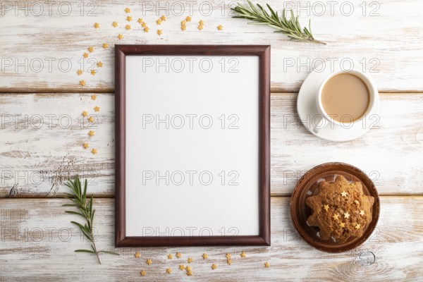 Brown wooden frame mockup with cup of coffee and cake on white wooden background. Blank, top view,