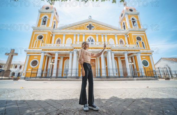 Beautiful tourist taking a selfie on the street of the cathedral in Granada, Nicaragua Young woman