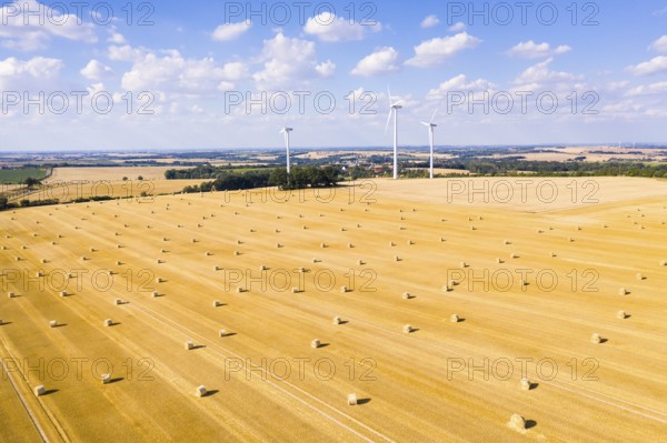 Straw bales on a harvested grain field from above, wind turbines in the background, Nossen, Saxony,