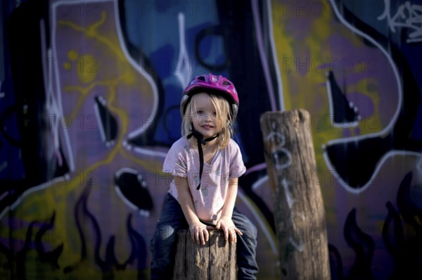 Little girl, 3 years, blonde, climbing, post, climbing facility, climbing frame, in front of wall