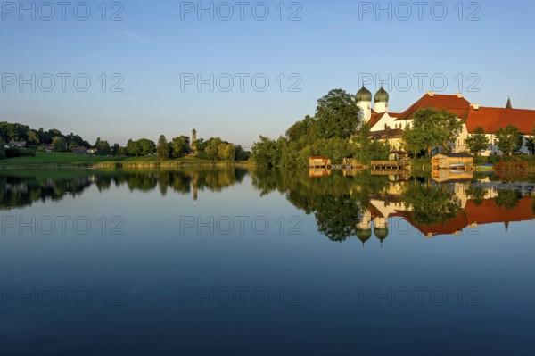 Romanesque Benedictine abbey Seeon monastery, monastery church St. Lambert with reflection in the