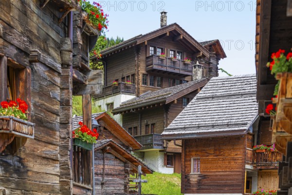 Old wooden houses with flower boxes in front of windows and balconies in the historic village