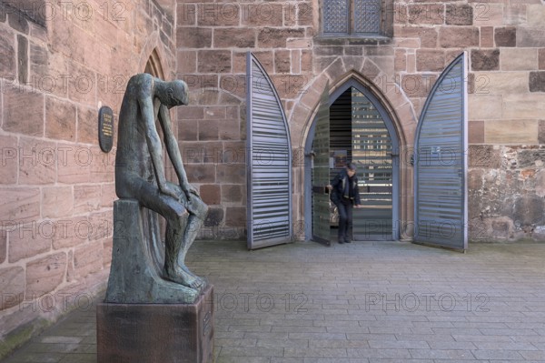 Main entrance of St Clare's Church, on the left the bronze sculpture of Job, created by the German