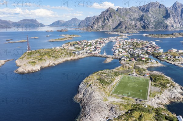 Aerial view over fishing village Henningsvaer, football stadium on rocky island, Lofoten, Norway,