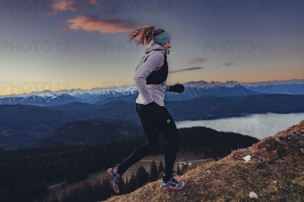 Trail running in autumn on the Jochberg on Lake Walchensee against the wonderful backdrop of the