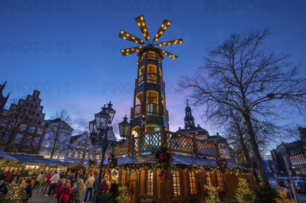 Christmas market with large Christmas pyramid at dusk, behind the historic town hall, Lüneburg,