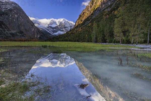 Snow-covered mountains reflected in lake, pond, autumn, Großer Ahornboden, Karwendel Mountains,