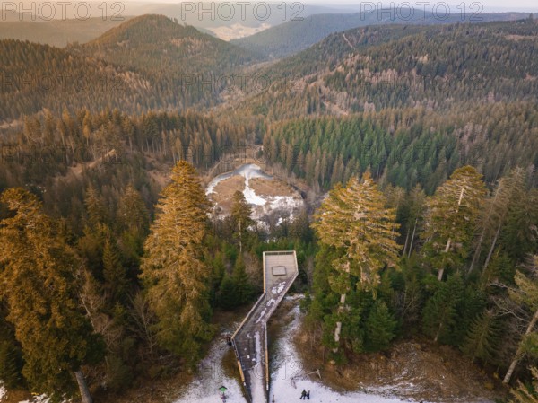 Panoramic view from the wooden walkway over snow-covered hills and forests, Ellbachseeblick viewing