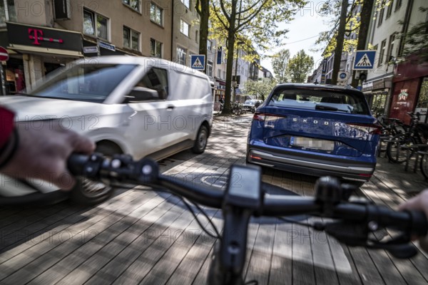 Cycling in the city, inner-city street, cycle lane, bicycles have priority, two-lane traffic with