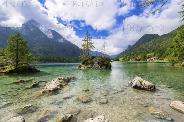 Hintersee near Ramsau with clear green water, surrounded by forests and mountains under a cloudy