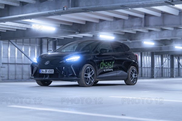 Black car with front lights switched on in car park, e-car sharing, Deer Mobility, MG4, Calw,