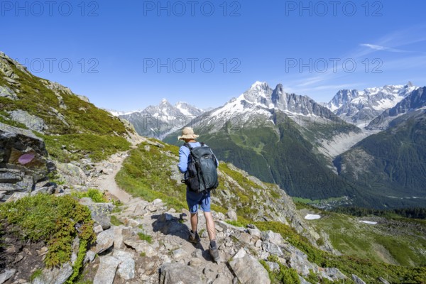 Mountaineer on a hiking trail in front of a mountain landscape, view of the mountain peaks Aiguille