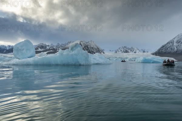 Dinghy with tourists, icebergs in front of glacier, -edge of Monacobreen, Liefdefjord, Woodfjord