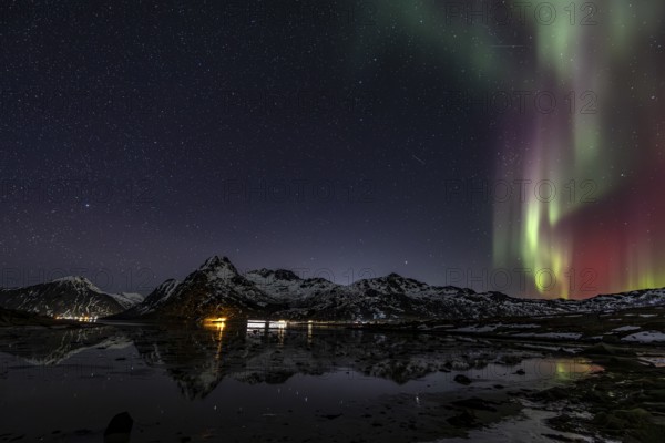 Northern lights over fjord, steep mountains, winter, aurora borealis, Flakstadoya, Lofoten, Norway,