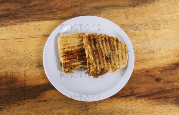 Top view of two meat and chicken panini on wooden table