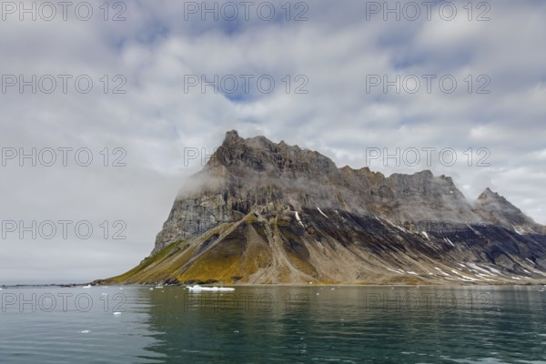 Gnalberget, mountain with steep sea cliffs in Hornsund fjord at Gnålodden in summer, Svalbard,