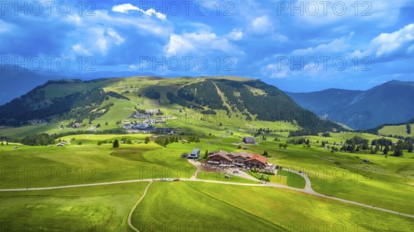 Stunning aerial view capturing green meadows, traditional houses, and rolling hills beneath a