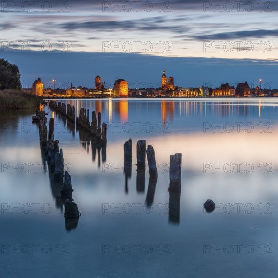 View at dusk over the Strelasund to the illuminated town of Stralsund with its churches and the