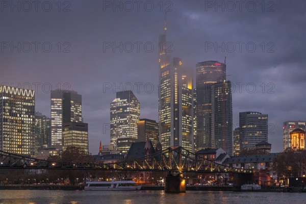 Low clouds envelop the shining towers of Frankfurt's banking skyline in the evening. Frankfurt am