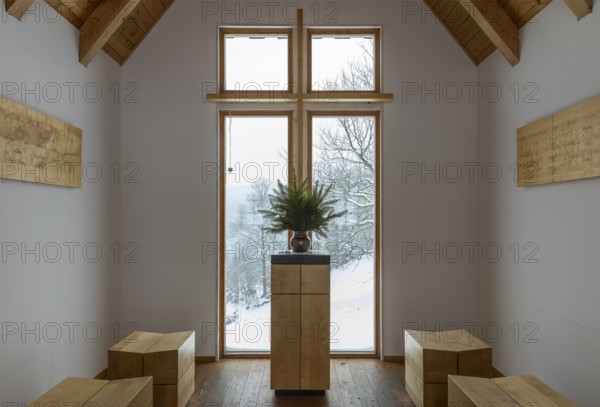 Interior of the chapel on the Glockenwanderweg trail with simple altar and small wooden benches,