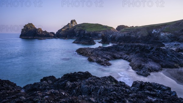 Kynance Cove with Asparagus Island, with sea, sandy beach and rocks in the evening at sunset.