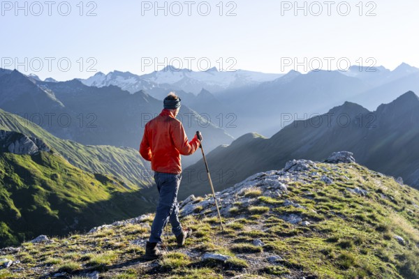 Hiker enjoying the mountain panorama in the morning, Venediger group, behind Dreiherrenkopf,