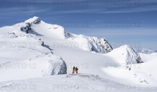 Two ski tourers in front of a snow-covered mountain landscape, Wildhorn in winter, Bernese Alps,