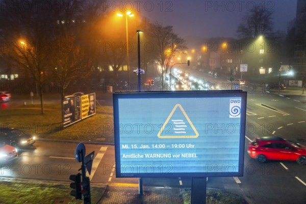 Dense fog, with visibility partly below 100 metres, city centre traffic at rush hour on